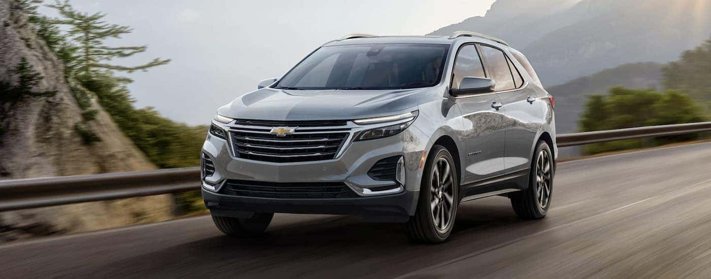 A silver 2023 Chevy Equinox LT is shown driving on a highway.