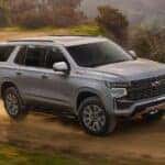 A grey 2024 Chevy Tahoe Z71 is shown driving on a trail after visiting a Chevy dealer near Patterson.