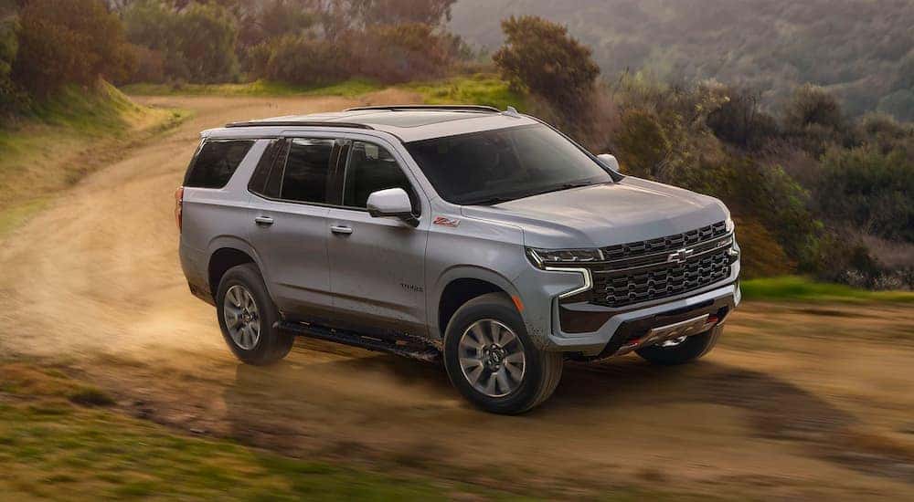 A grey 2024 Chevy Tahoe Z71 is shown driving on a trail after visiting a Chevy dealer near Patterson.