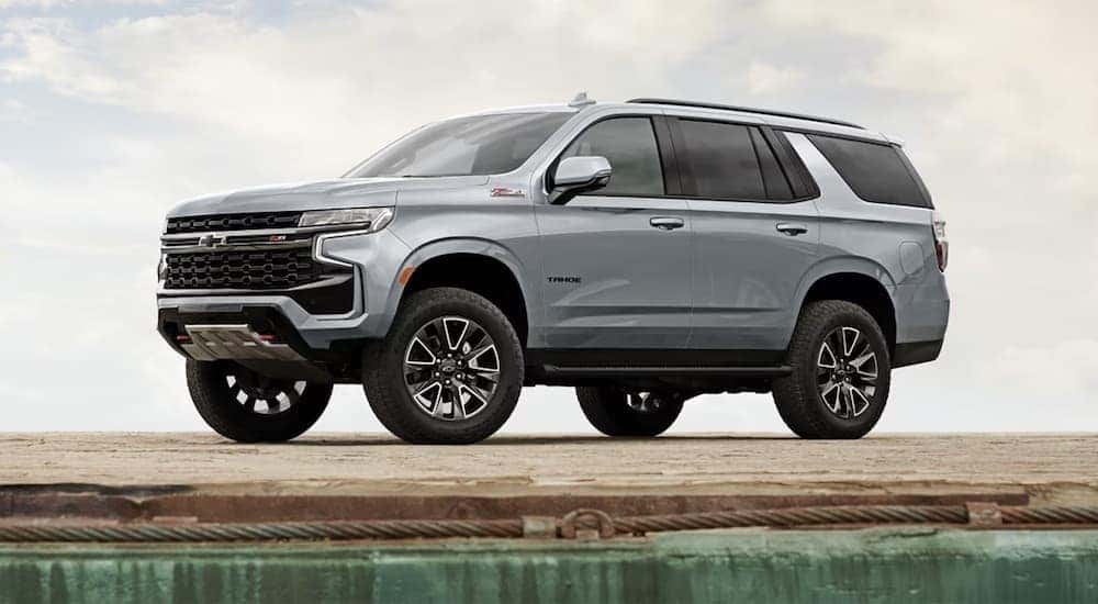 A grey 2024 Chevy Tahoe Z71 is shown parked near a lake.