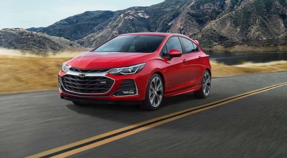 A red 2019 Chevy Cruze RS is shown driving on a highway after visiting a Chevy dealer near Pleasant Valley.