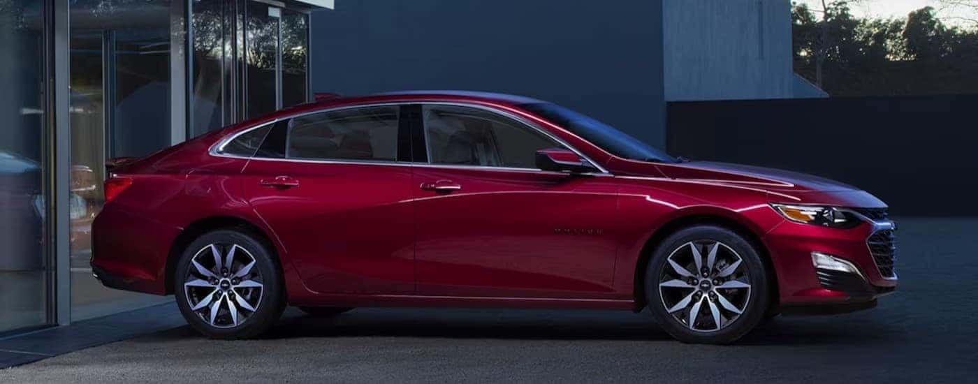 A red 2024 Chevy Malibu is shown parked near a Chevy dealer near Pleasant Valley.