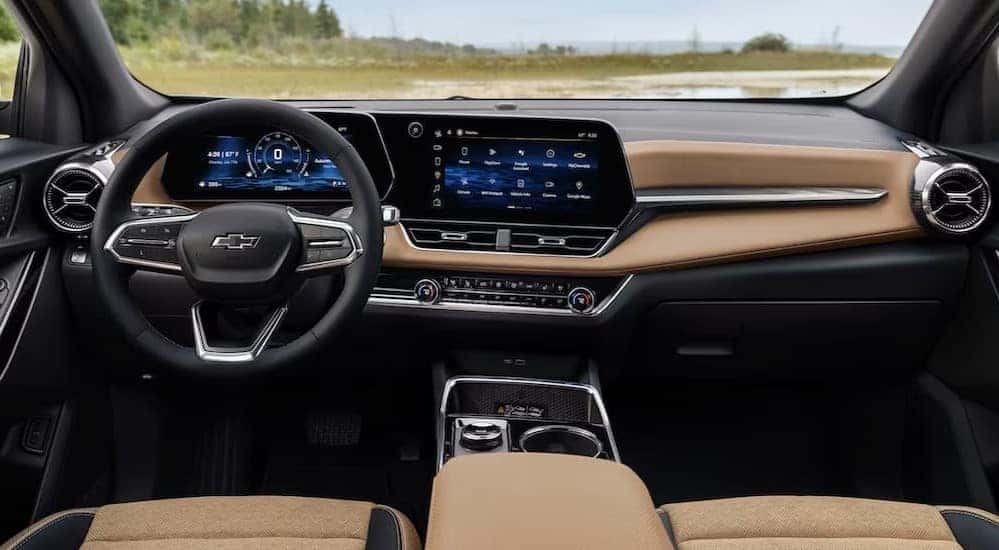 The black and brown interior and dash of a 2025 Chevy Equinox is shown.