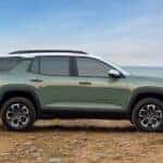 A green 2025 Chevy Equinox ACTIV is shown parked near water after visiting a Chevy dealer near Pleasant Valley.