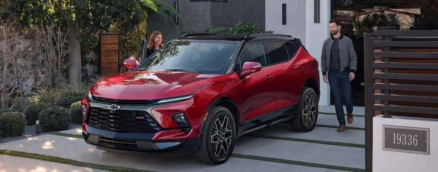 A red 2024 Chevy Blazer RS is shown parked on a driveway.