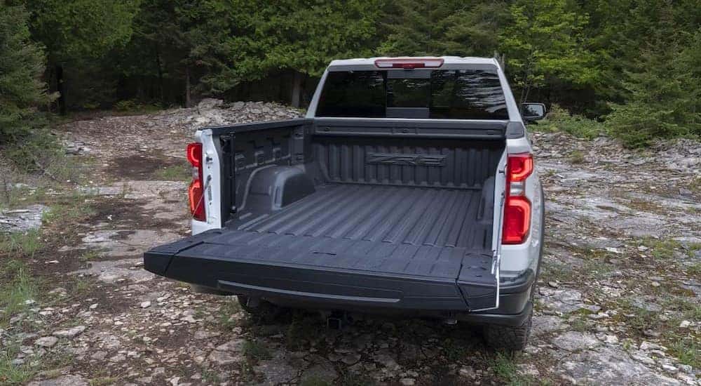 A white 2024 Chevy Silverado 1500 ZR2 is shown from the rear with an open tailgate.