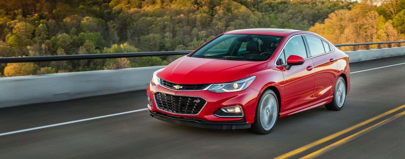 A red 2018 Chevy Cruze RS is shown driving on a highway.