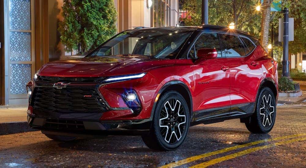 A red 2024 Chevy Blazer RS parked by a curb.