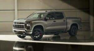 A silver 2024 Chevy Silverado 1500 Redline Edition is shown parked in a warehouse.