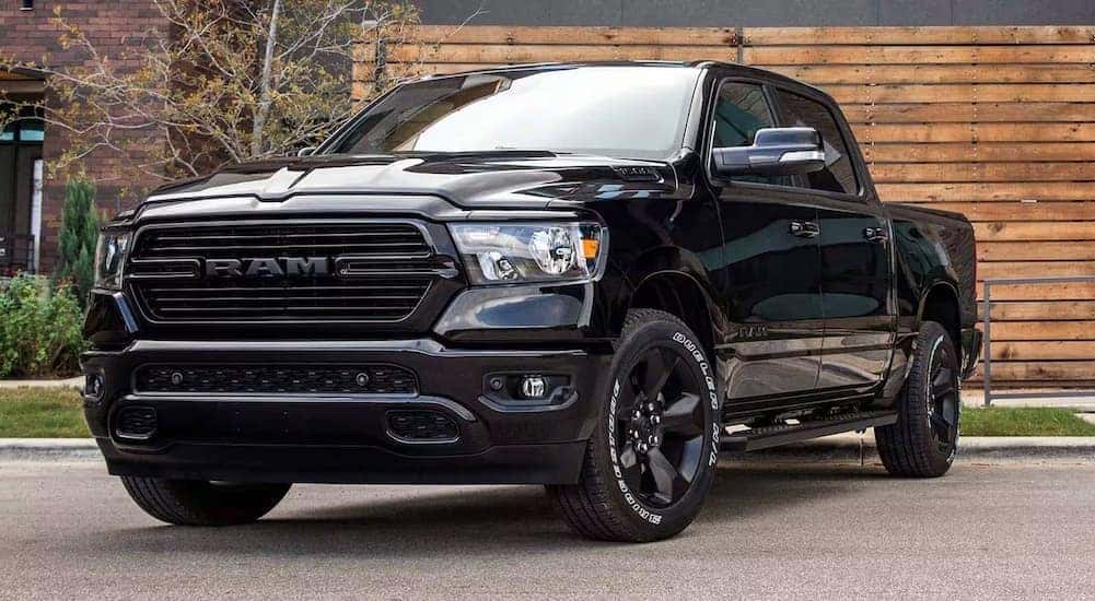 A black 2024 Ram 1500 DT is shown parked on a driveway.