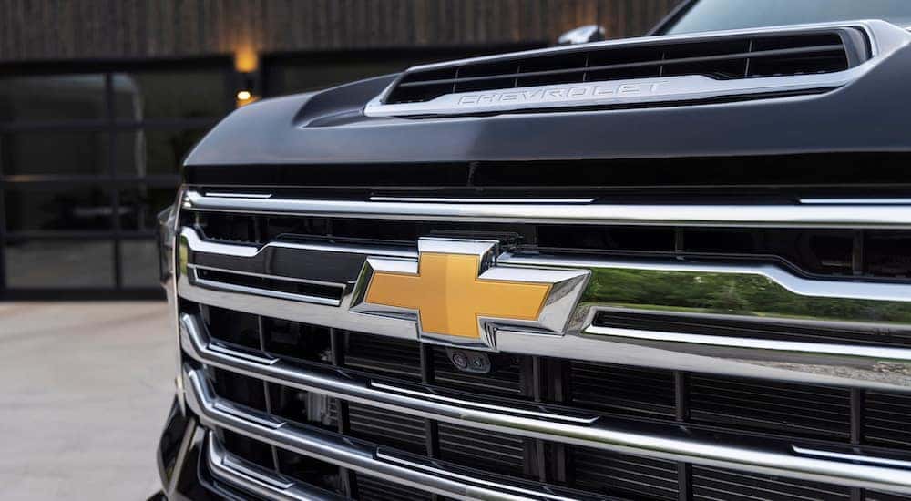 A black 2024 Chevy Silverado 2500 HD High Country is shown from the front in close-up.