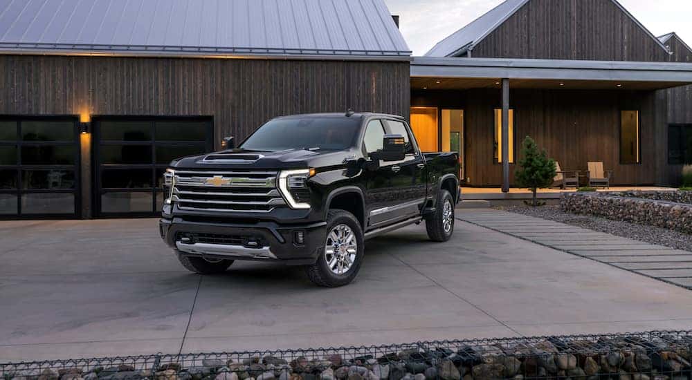 A black 2024 Chevy Silverado 2500 HD High Country is shown from the front at an angle.