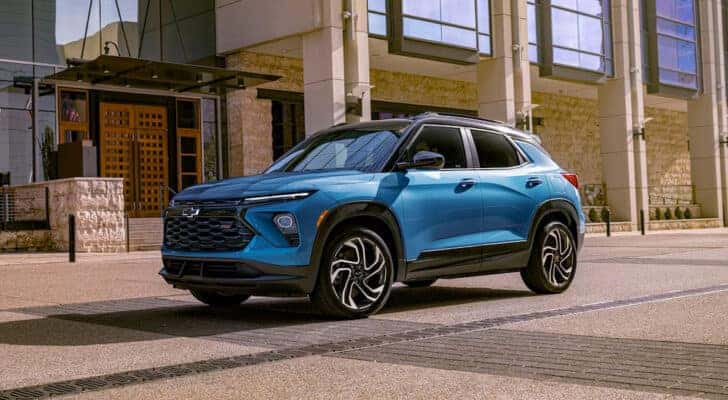 A blue 2025 Chevy Trailblazer RS driving through a city.