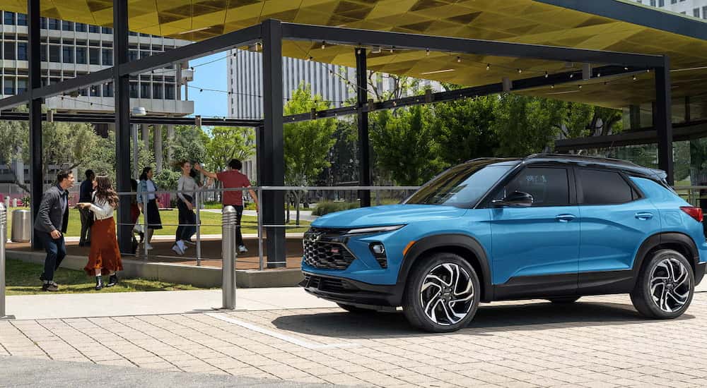 A blue 2025 Chevy Trailblazer RS driving through a city.