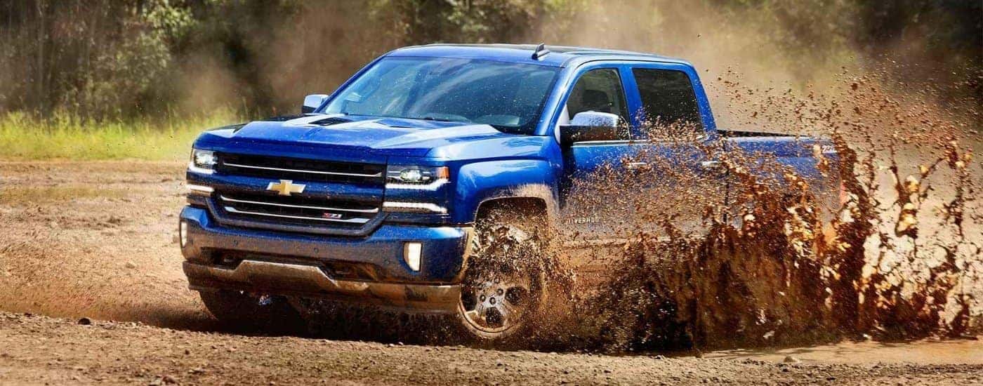 A blue 2016 Chevy Silverado 1500 Z71 is shown kicking up dust.