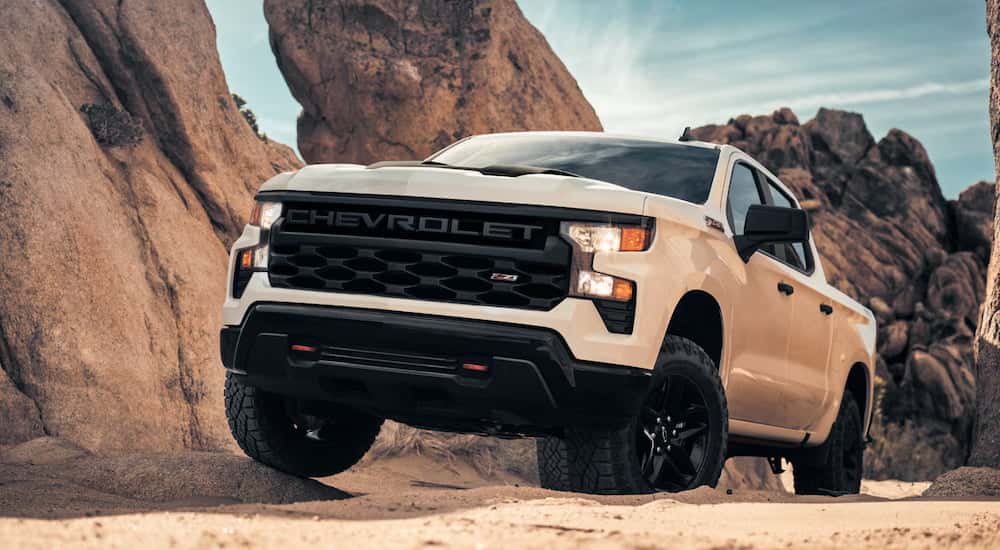 A white 2025 Chevy Silverado 1500 Z71 driving up a dirt hill.