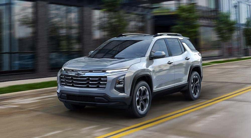 A silver 2025 Chevy Equinox for sale in Millbrook driving down a road.