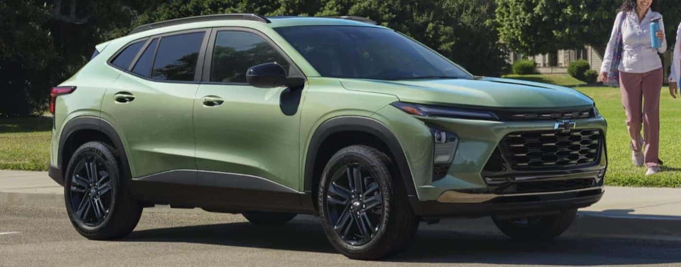 A green 2025 Chevy Trax ACTIV is shown parked near people.