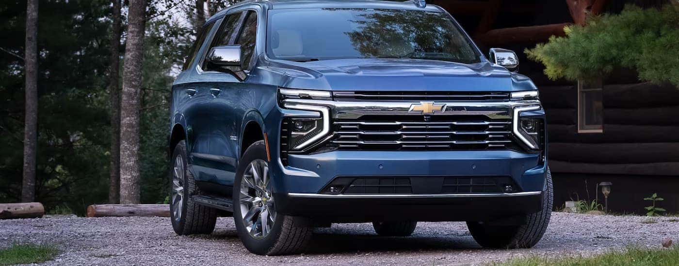 A blue 2025 Chevy Tahoe parked on gravel driveway