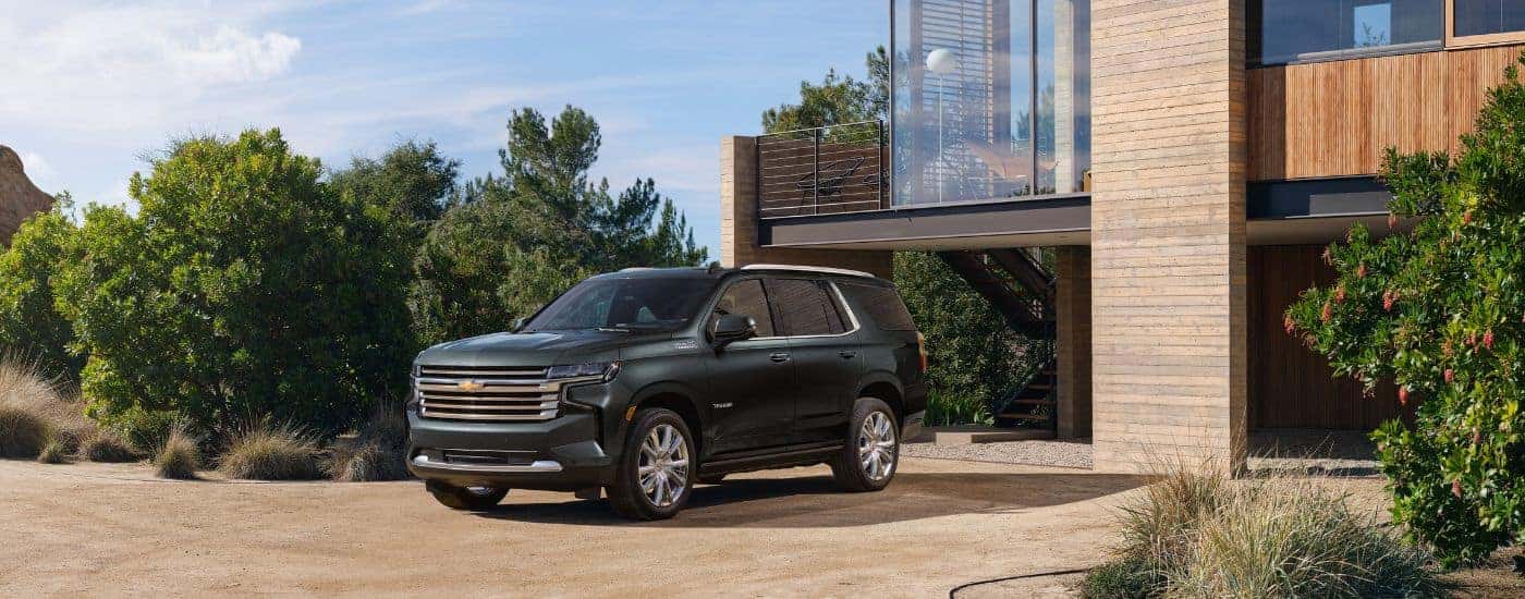 A blue 2022 Chevy Tahoe High Country is shown parked on a driveway.