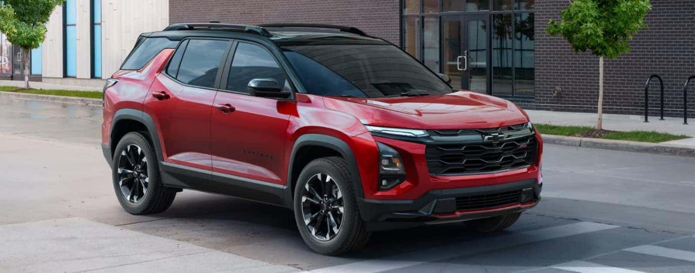 A red 2025 Chevy Equinox RS for sale near Poughkeepsie parked in front of a building.