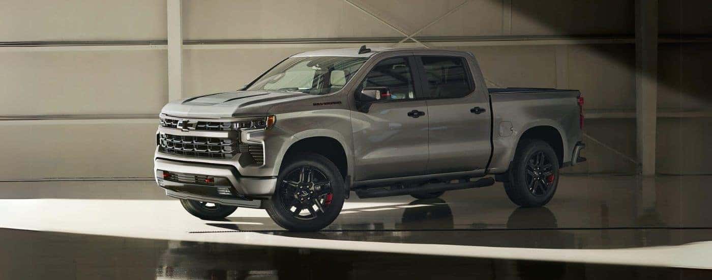 A silver 2024 Chevy Silverado 1500 Redline Edition is shown parked in a warehouse.