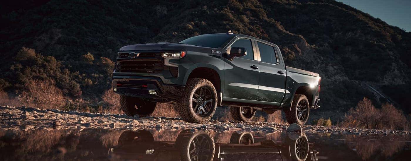 A black 2025 Chevy Silverado 1500 for sale in Millbrook is shown off-road.