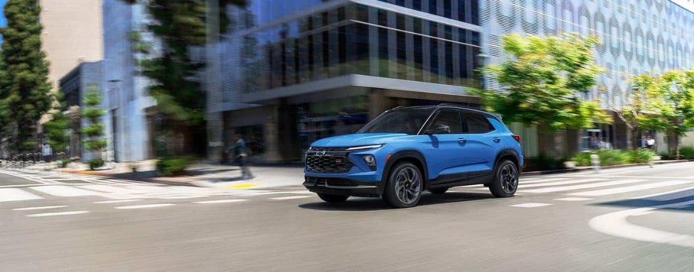 A blue 2025 Chevy Trailblazer RS driving through a city.
