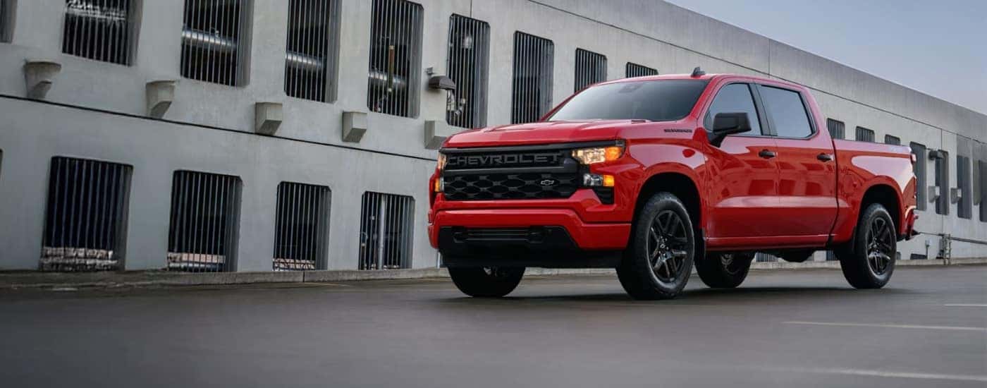 A red 2025 Chevy Silverado 1500 parked in front of a building.