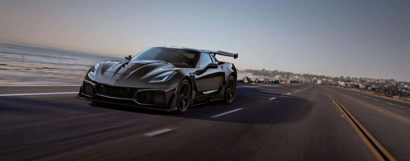 A black 2019 Chevy Corvette ZR1 is shown driving on a highway after visiting a Dover Plains Chevy dealer.