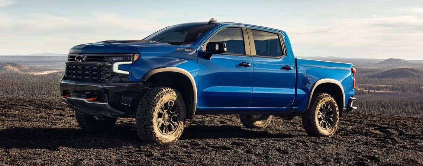 A blue 2022 Chevy Silverado 1500 ZR2 is shown driving on a dirt trail.