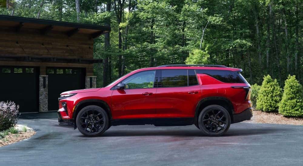 A red 2025 Chevy Traverse RS parked in a driveway