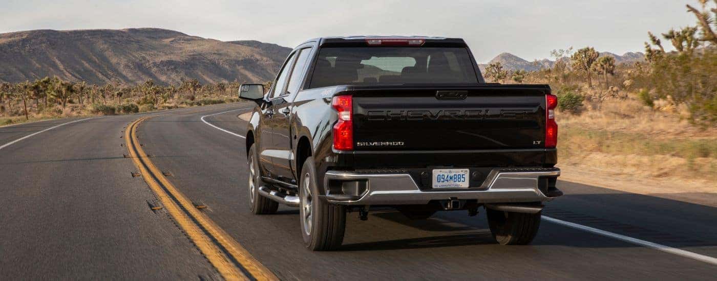 Black 2022 Chevy Silverado 1500 driving down an empty road