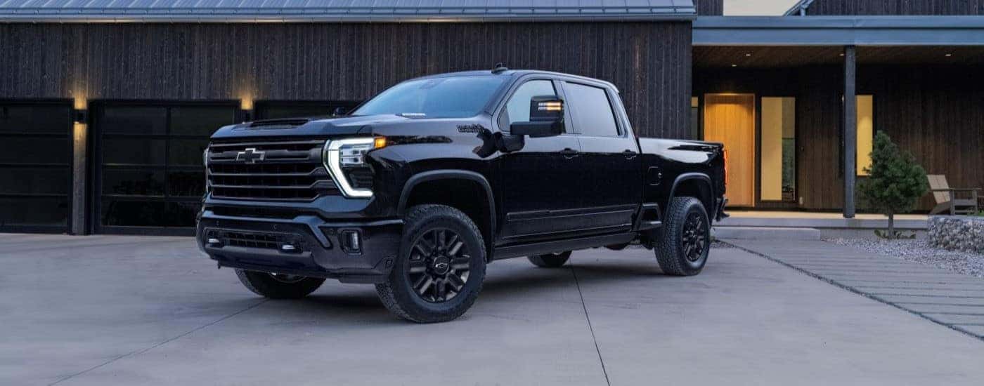 Black 2024 Chevy Silverado 2500 HD High Country parked to look at trucks for sale