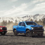A red, a blue, and a white 2026 Chevy Silverado 1500 parked side by side