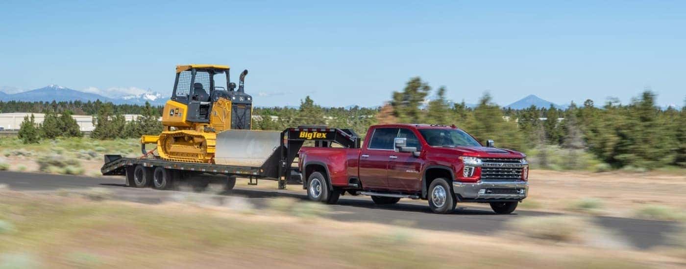 Red 2022 Chevy Silverado 3500 HD towing a bulldozer