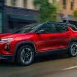A red 2026 Chevy Equinox RS driving in a city.