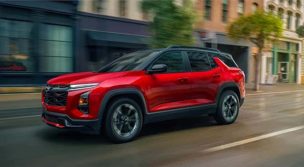 A red 2026 Chevy Equinox RS driving in a city.