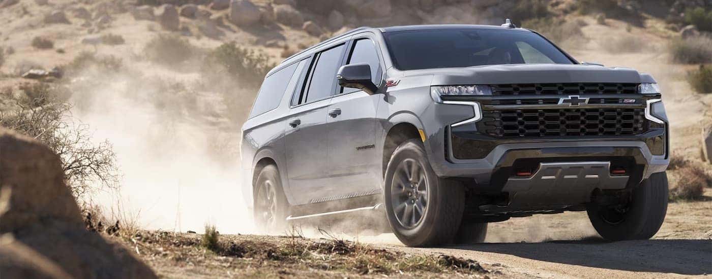 Silver 2024 Chevy Suburban Z71 driving off-road.