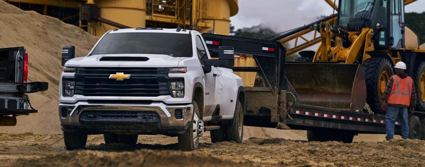 White 2026 Chevy Silverado 3500 HD towing construction equipment
