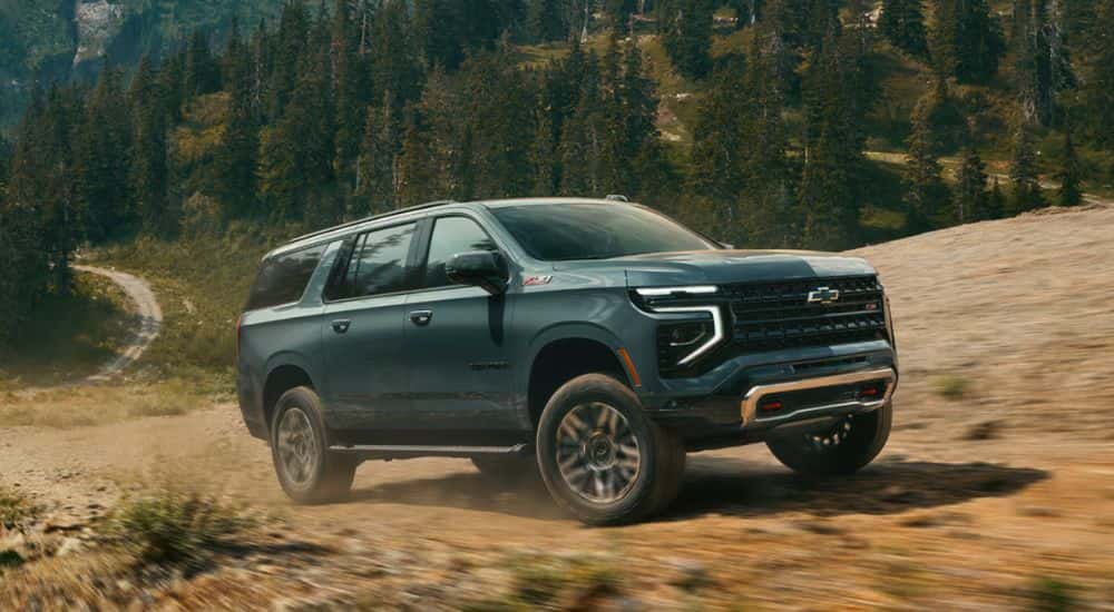 Green 2026 Chevy Suburban off roading up a mountain
