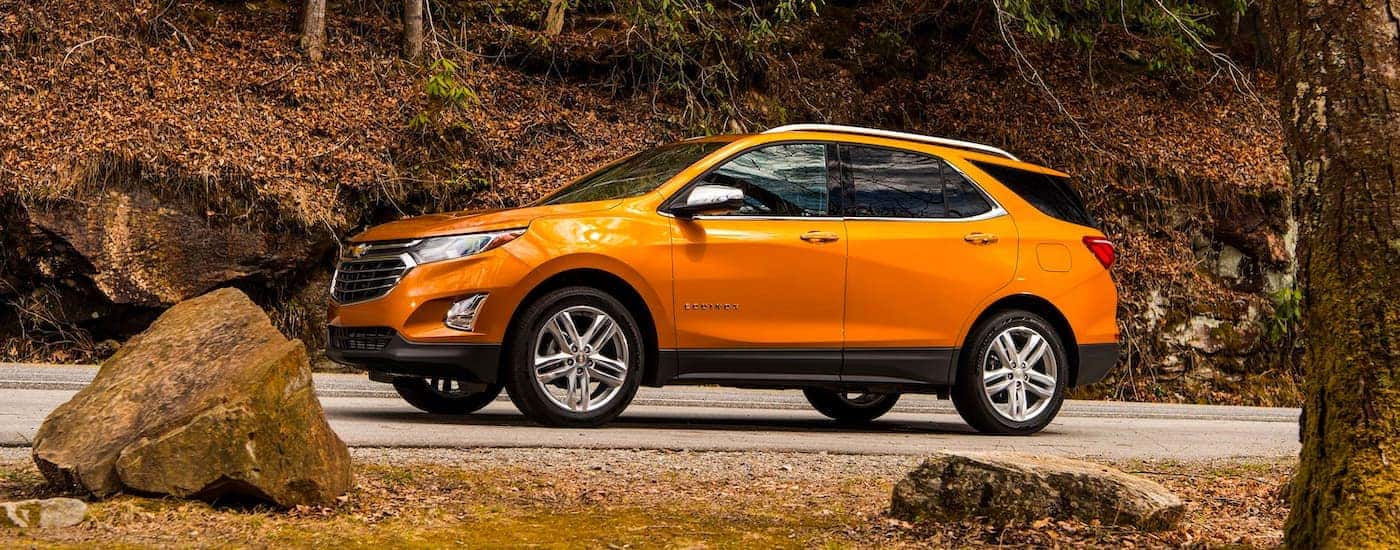 Orange 2019 Chevy Equinox driving on a forest road