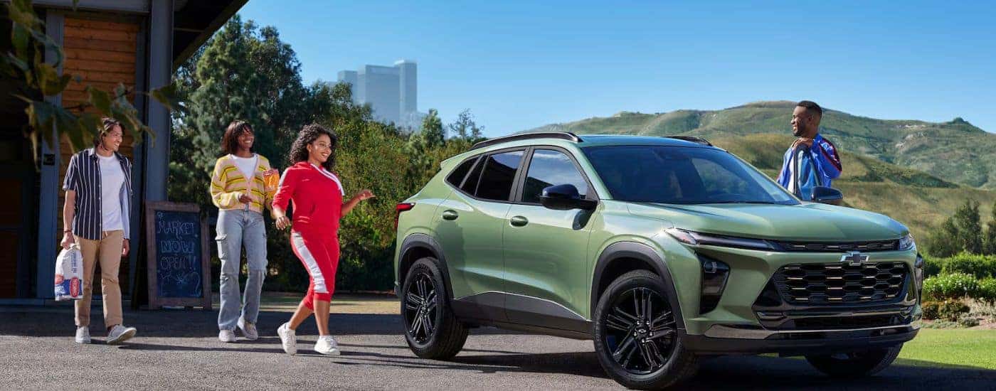 Green 2026 Chevy Trax parked with friends walking toward it