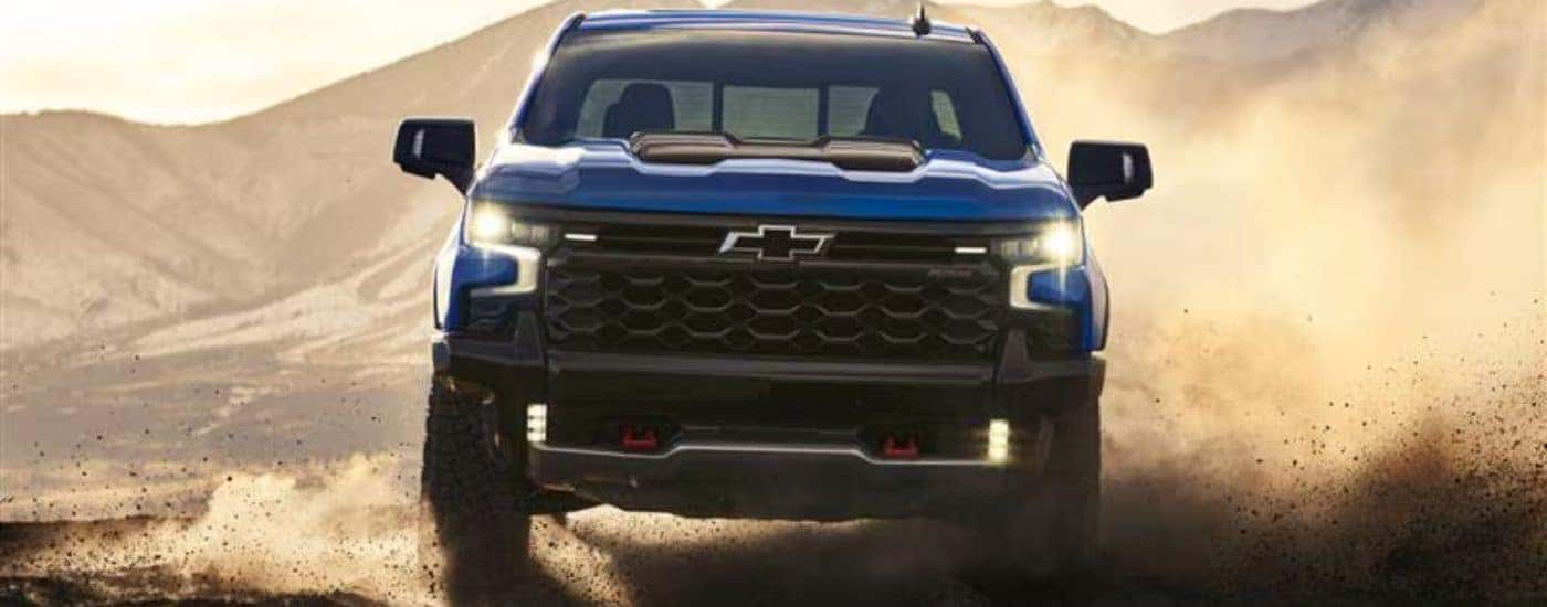 Blue 2026 Chevy Silverado 1500 ZR2 kicking up dust off-road.