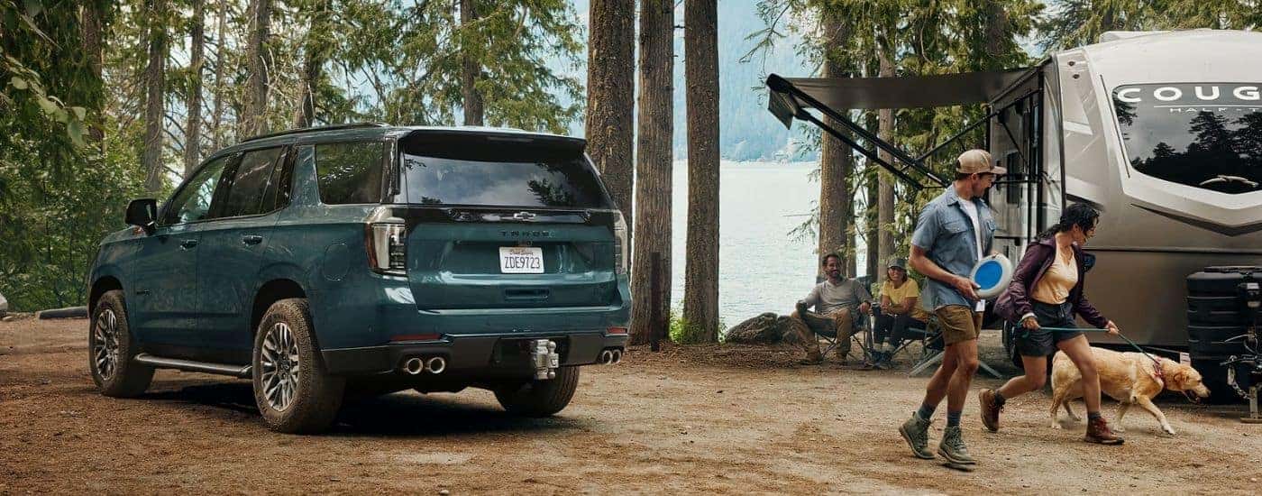 A green 2026 Chevy Tahoe Z71 next to people and a dog.