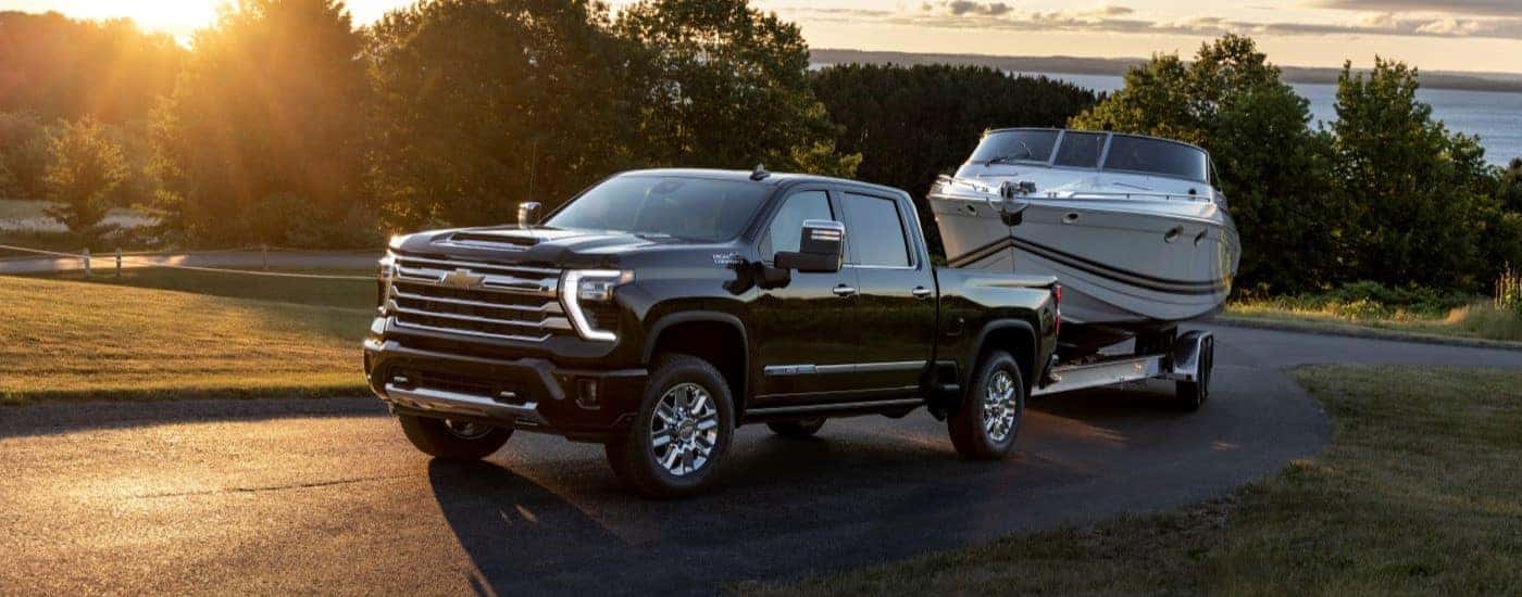 Black 2026 Chevy Silverado 2500 towing a boat.