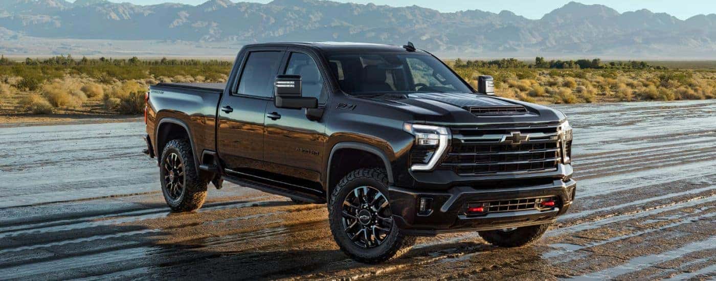 A black 2026 Chevy Silverado 2500 HD Z71 Stars & Steel Edition parked on a wet dirt field.