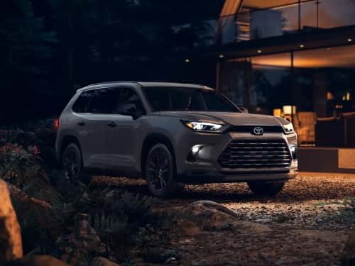2025 Toyota Grand Highlander parked outside a modern home at night