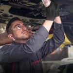 A car mechanic changing the oil in a Nissan
