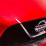 The front of a red Nissan showcasing the logo